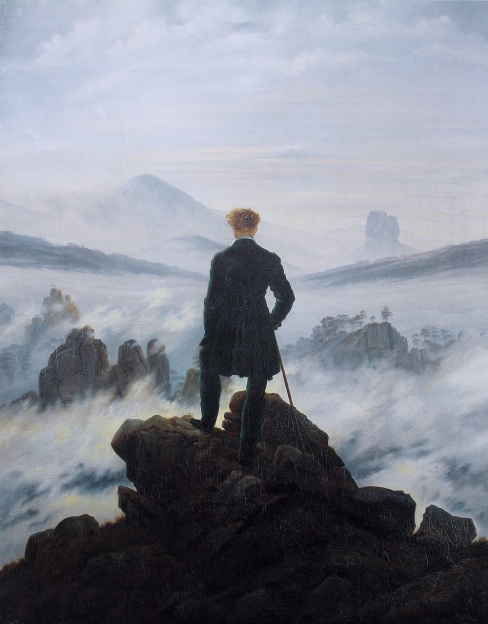 Man at the top of a mountain looking out 